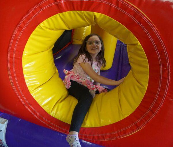 Navaeh Smalstig, 8, climbs out of a bouncy house at Jump City in Imlay City, Mich., on May 13, 2022. (Steven Kovac/The Epoch Times)