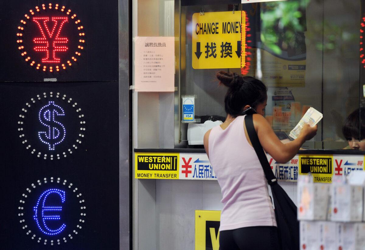 <br/>A woman exchanges money at a currency exchange shop in Hong Kong on Sept. 15, 2011. Hong Kong said it has no plans to unpeg its currency from the US dollar, amid growing calls to end the 28-year peg to allow the Hong Kong dollar to appreciate against the greenback. (Laurent Fievet/AFP via Getty Images)