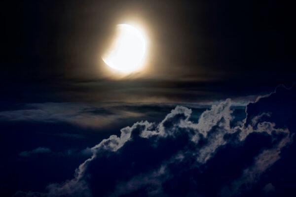 A lunar eclipse begins as the full moon sets over the hills of the Taunus mountains near Frankfurt, Germany, on May 16, 2022. (Michael Probst/AP Photo)