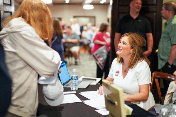 Shannon Adcock speaks with an attendee at an event co-hosted by Awake Illinois and other local organizations in Rockford, Ill., on May 9, 2022. (Cara Ding/The Epoch Times)