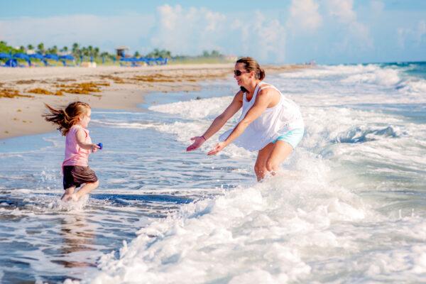 A mother and child play in the surf at Delray Beach, Fla. (Discover the Palm Beaches)