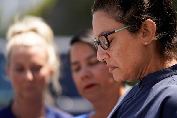 Erica Triplett (R), an office manager for Dr. John Cheng, is emotional as she reads a statement outside their office building in Aliso Viejo, Calif. on May 17, 2022. (Ashley Landis/AP Photo)