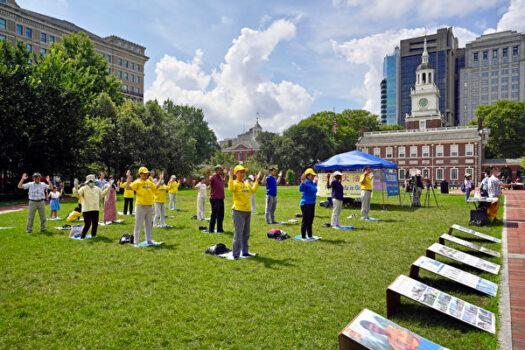 Santhosh Krishnamurthy (middle in purple cloth) doing Falun Dafa exercises at Independence National Historical Park in Philadelphia, Pa., on July 10, 2021 (Serena Shi/The Epoch Times)