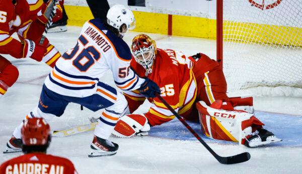 Edmonton Oilers right wing Kailer Yamamoto (L), scores on Calgary Flames goalie Jacob Markstrom during third period NHL second round playoff hockey action in Calgary, on May 18, 2022. (Jeff McIntosh/The Canadian Press via AP)