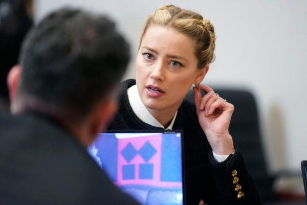 Actress Amber Heard speaks with a member of her legal team in the courtroom at the Fairfax County Circuit Courthouse in Fairfax, Va., on May 19, 2022. (Shawn Thew/Pool Photo via AP)