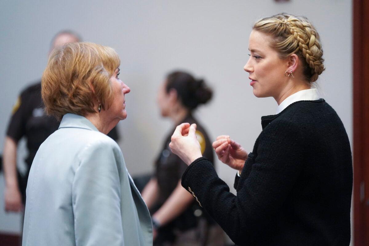 Actress Amber Heard speaks with her attorney Elaine Bredehoft during a break at the Fairfax County Circuit Courthouse in Fairfax, Va., on May 19, 2022. (Shawn Thew/Pool Photo via AP)
