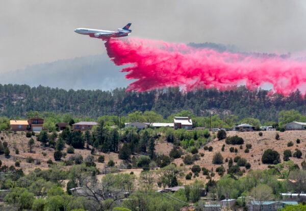 A slurry bomber dumps the fire retardant between the Calf Canyon/Hermit Peak Fire and homes on the westside of Las Vegas, N. Mex, on May 3, 2022. (Eddie Moore/The Albuquerque Journal via AP)