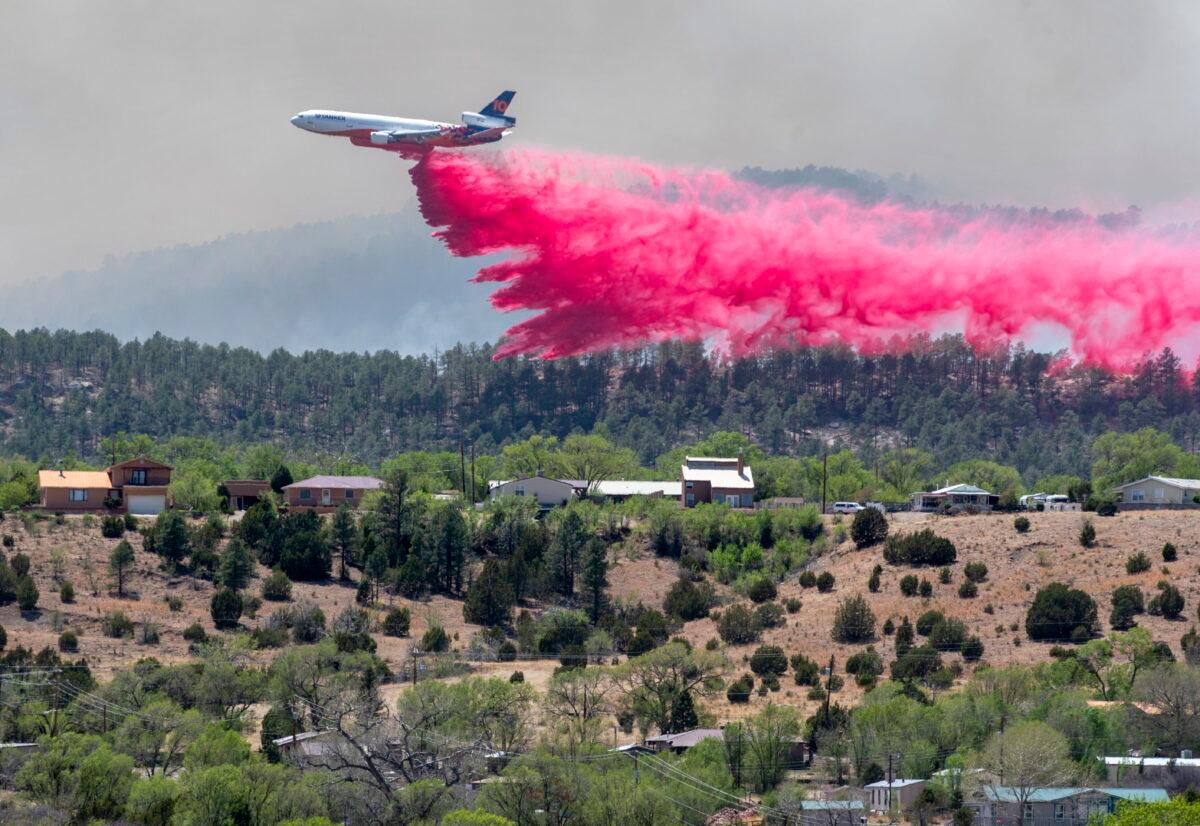 A slurry bomber dumps fire retardant between the Calf Canyon/Hermit Peak Fire and homes on the west side of Las Vegas, N.M., on May 3, 2022. (Eddie Moore/The Albuquerque Journal via AP)