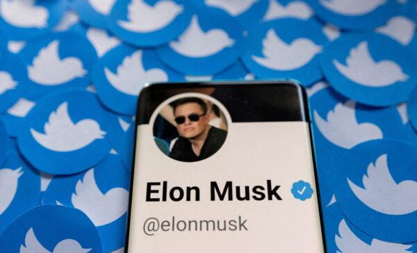 Elon Musk's Twitter profile on a smartphone placed on printed Twitter logos on April 28, 2022. (Dado Ruvic/Illustration/Reuters)