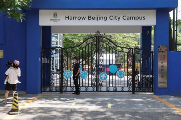 People stand outside the entrance of a Harrow International School campus, which is closed amid the COVID-19 outbreak in Beijing, on May 18, 2022. (Carlos Garcia Rawlins/Reuters)