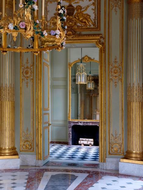 A view from the reception room through to one of the wings in the French Pavilion reveals the refined gold leaf plaster work and subtle green and pink hues of the marble, which draw on colors found in the surrounding garden. (T. Garnier/Château de Versailles)