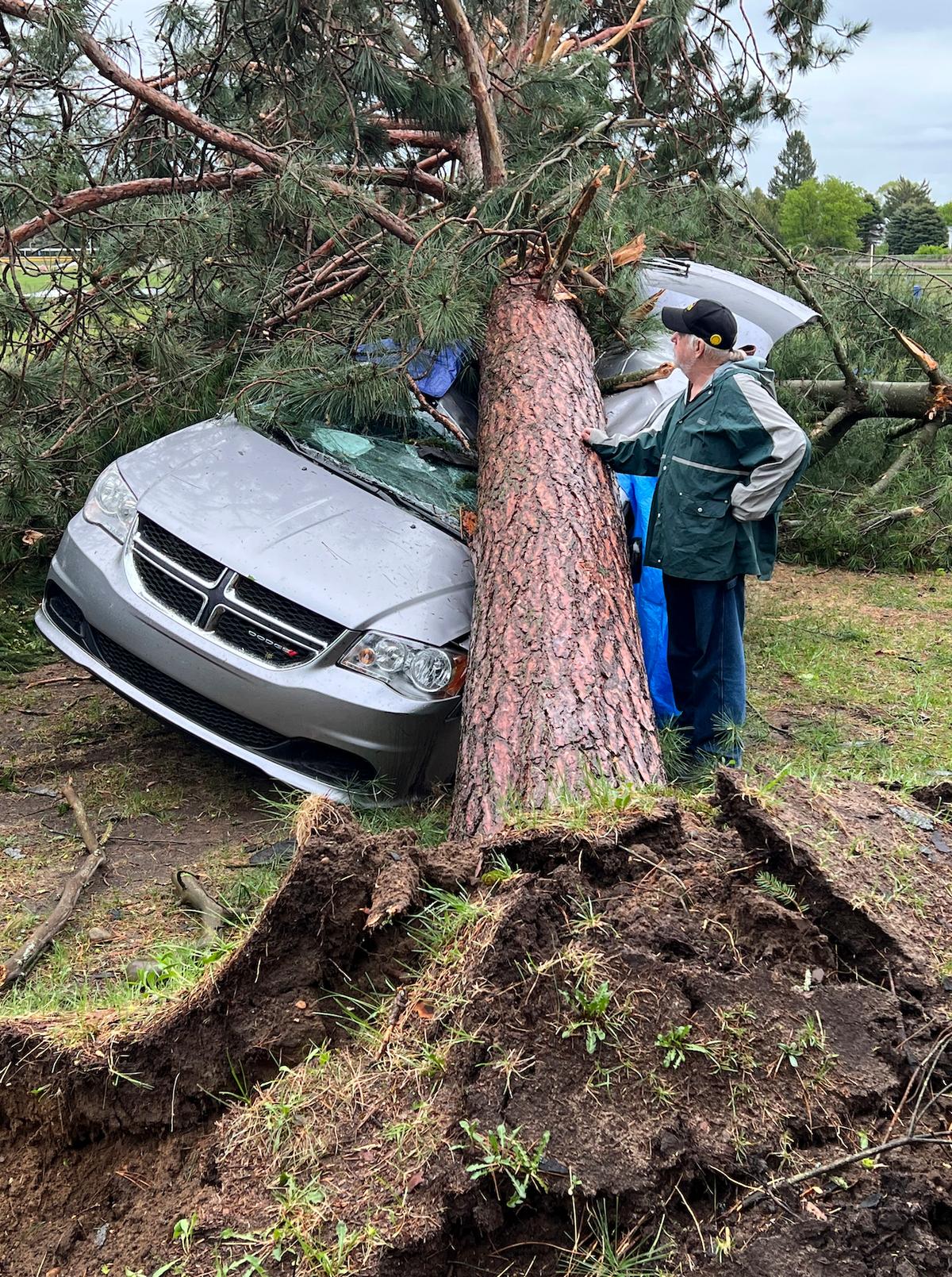 Jack Elliott inspects his 2017 Dodge in Gaylord, Mich., on May 20, 2022, after a red pine crushed the vehicle during a tornado. (John Russell/AP Photo)