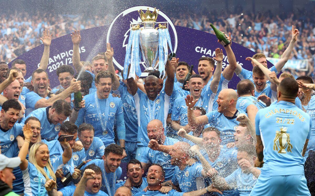 Manchester City's Fernandinho lifts the trophy as he celebrates with teammates after winning the Premier League at Etihad Stadium in Manchester, England, on May 22, 2022. (Hannah Mckay/Reuters)