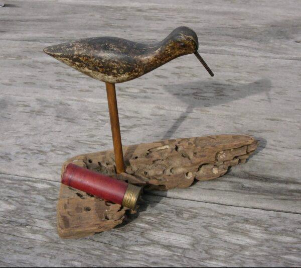 A shorebird decoy stands on driftwood. Made around 1900, it has tacks for eyes and a nail for its bill. It is part of the author’s personal collection. (Courtesy of John V. Quarstein )