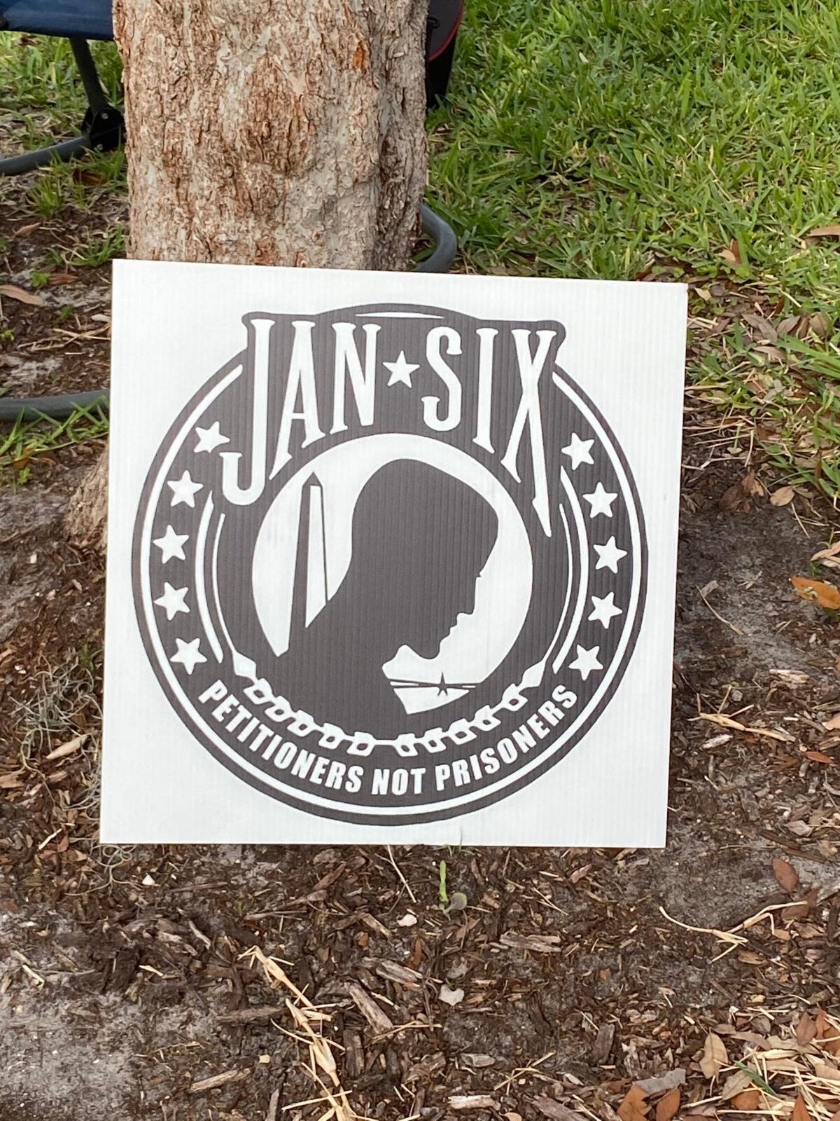 A sign bearing the "Jan-Six" logo, designed to represent the prisoners being held for their participation or simple presence at the Stop the Steal rally in Washington on Jan. 6, 2021, is spotted at a rally in Pinellas County, Fla., on May 22, 2022. (Patricia Tolson/The Epoch Times)