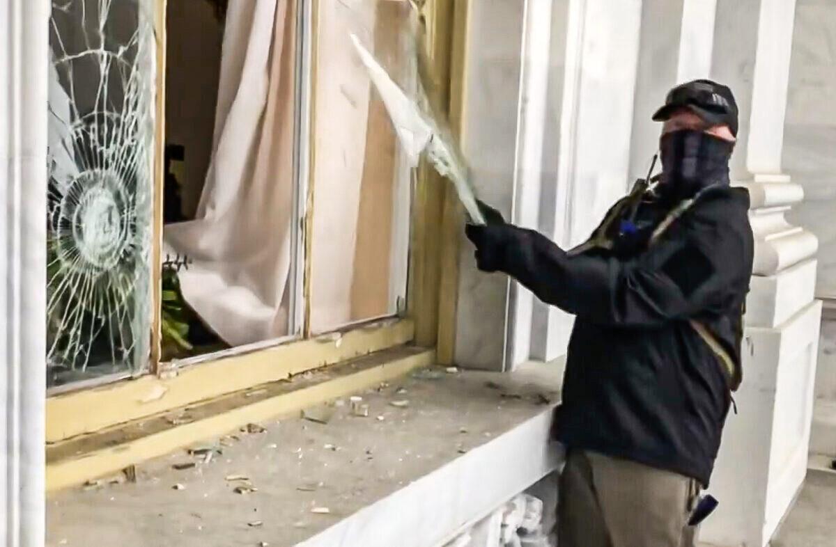 A suspicious actor vandalized a Capitol window on Jan. 6, 2021. He has not been placed on the FBI wanted list nor arrested or charged. (Bobby Powell/Screenshot by The Epoch Times)