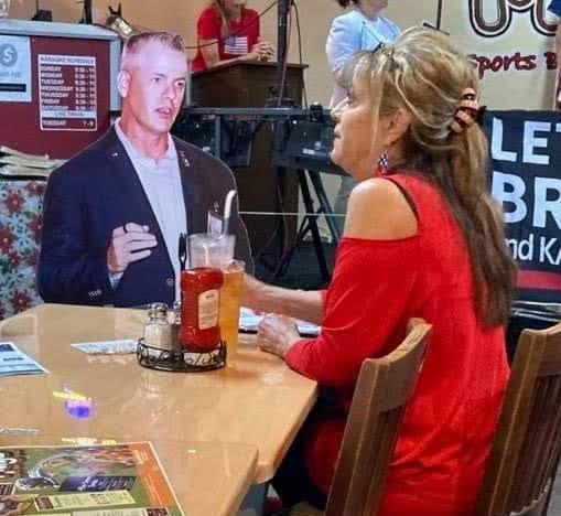 Cathi Chamberlain takes a break at a local restaurant to strategize about Jeremy Brown's campaign with her companion cardboard cutout of Brown, a Jan. 6 prisoner and candidate for Florida State House. (Courtesy of Cathi Chamberlain)