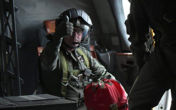 A crew member on a RNZAF Orion prepares to drop a survival pack to those on board two missing boats from Kiribati on May 23, 2022. (New Zealand Defence Force)