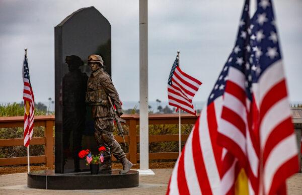 People walk through a display of 1776 American flags displayed in Castaways Park in Newport Beach, Calif., on May 23, 2022. (John Fredricks/The Epoch Times)