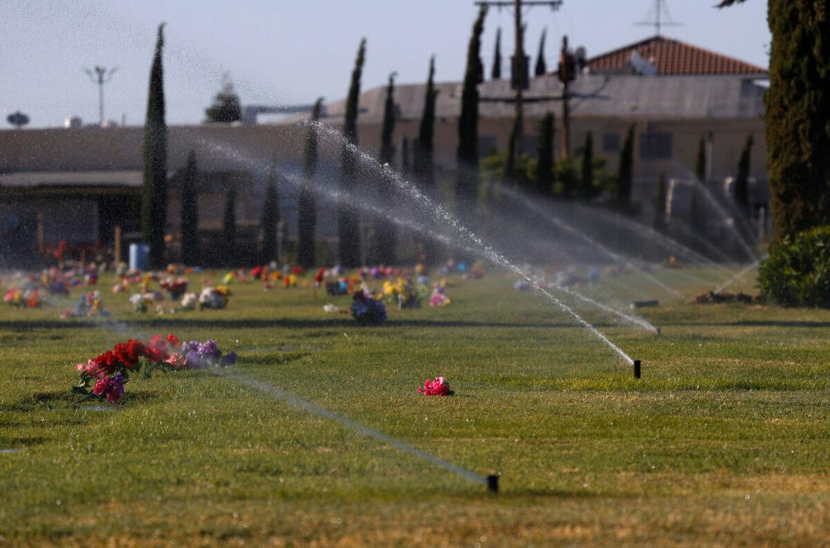 Sprinklers water the grass at Dos Palos Cemetery in Dos Palos, Calif., on May 25, 2021. (Justin Sullivan/Getty Images)