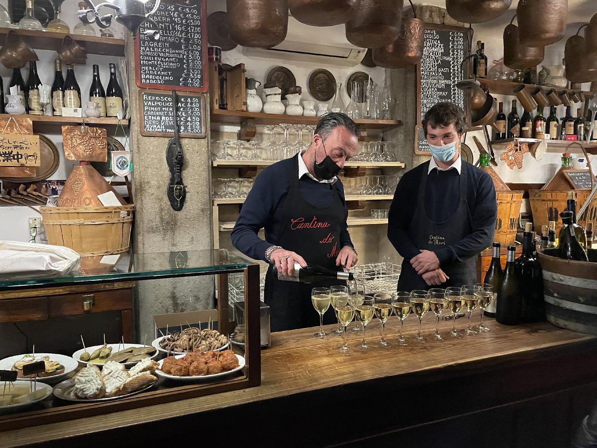 Local Prosecco is poured at Cantina do Mori beneath metal pails that were once used to gather fresh water. (Photo courtesy of Lesley Sauls Frederikson.)