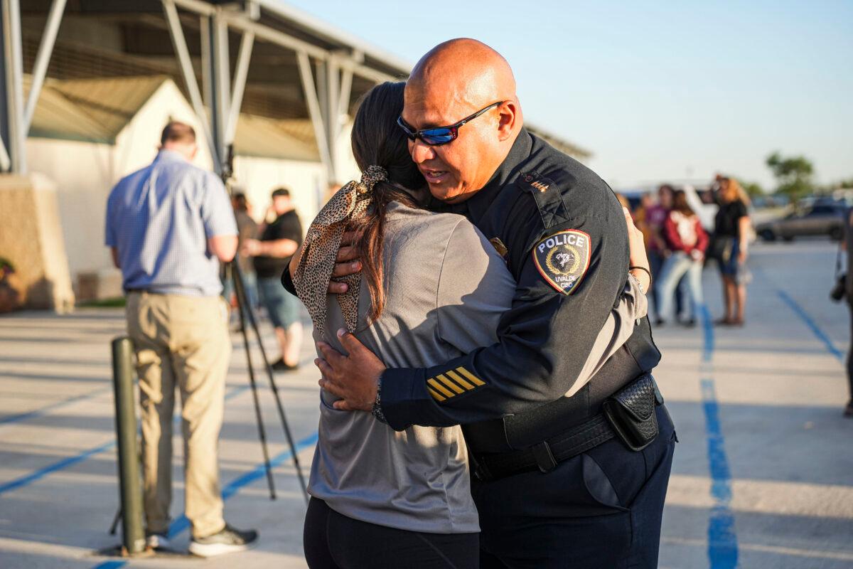 Uvalde school district Chief of Police Pete Arredondo hugs a school student at a community prayer evening held the day after a mass shooting at Robb Elementary School that killed 19 children and 2 teachers, in Uvalde, Texas, on May 25, 2022. (Charlotte Cuthbertson/The Epoch Times)