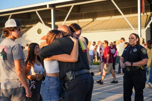 Uvalde school district Chief of Police Pete Arredondo hugs school students at a community prayer evening held the day after a mass shooting at Robb Elementary School that killed 19 children and 2 teachers, in Uvalde, Texas, on May 25, 2022. (Charlotte Cuthbertson/The Epoch Times)
