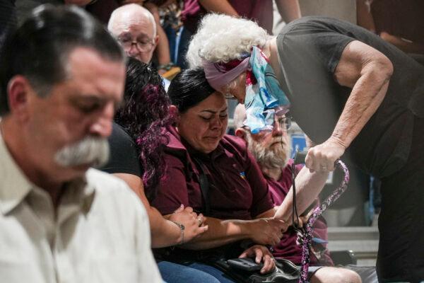 Uvalde residents comfort each other at a community prayer evening held the day after a mass shooting at Robb Elementary School in Uvalde, Texas, on May 25, 2022. (Charlotte Cuthbertson/The Epoch Times)