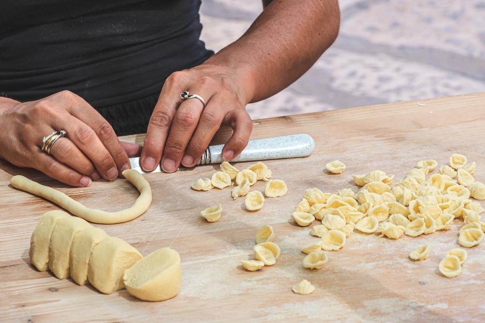 A woman prepares orecchiette, a pasta typical of Puglia and Apulia. (Michele Ursi/Shutterstock)