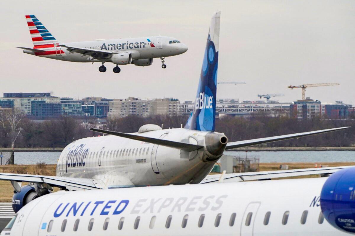 An American Airlines aircraft flies past JetBlue and United Express aircraft as it lands at Reagan National Airport in Arlington, Va., on Jan. 24, 2022. (Joshua Roberts/Reuters)