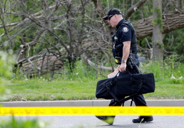 A police officer works at the scene where police shot a suspect who was walking down a city street carrying a gun in Toronto on May 26, 2022. (Reuters/Chris Helgren)