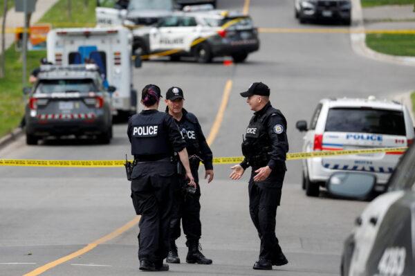 Police officers work at the scene where police shot a suspect who was walking down a city street carrying a gun in Toronto on May 26, 2022. (Reuters/Chris Helgren)