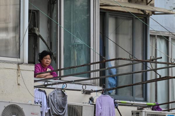  A resident looks out from her window during a COVID-19 lockdown in the Jing'an district of Shanghai on May 25, 2022. (Hector Retamal/AFP via Getty Images)