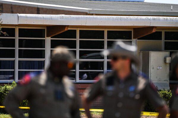 Police officers stand outside the Robb Elementary School in Uvalde, Texas, on May 25, 2022, after a teen in body armor marched into the school and killed 19 children and two teachers. (Chandan Khanna/AFP via Getty Images)