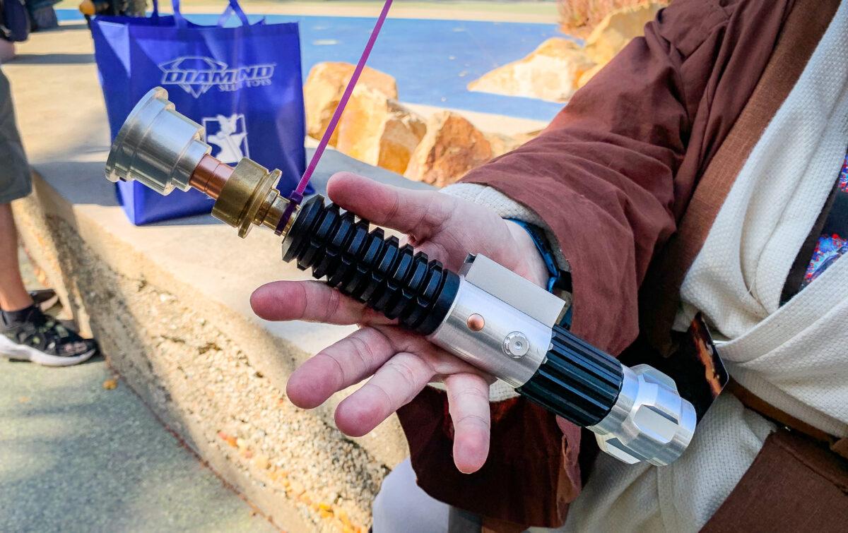 A Star Wars fan holds a light saber in Anaheim, Calif., on May 26, 2022. (John Fredricks/The Epoch Times)