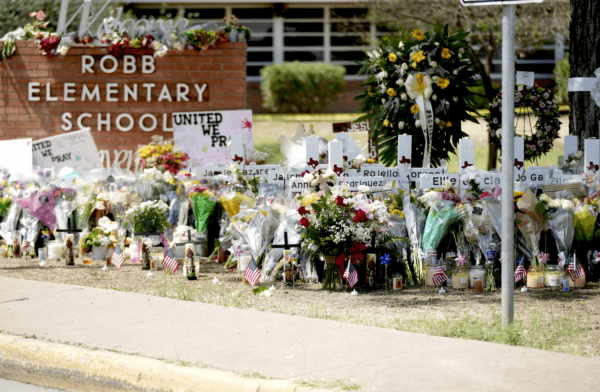  A makeshift memorial at Robb Elementary School is filled with flowers, toys, signs, and crosses bearing the names of all 21 victims of the mass shooting that occurred on May 24, in Uvalde, Texas, on May 27, 2022. (Charlotte Cuthbertson/The Epoch Times)