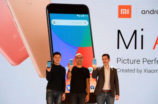(L-R) Donovan Sung, director of product management and marketing, at Xiaomi Global; Manu Jain, managing director of Xiaomi India; and global director of Android Partner Programs Jon Gold hold the newly launched Xiaomi Mi A1 smartphone at a function in New Delhi on Sept. 5, 2017. (SAJJAD HUSSAIN/AFP via Getty Images)