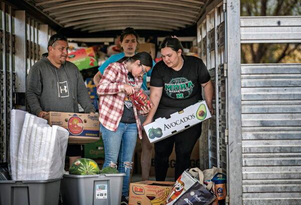Gabriella Duran (far right) and local volunteers at the Mora Head Start building, help sort through food donated to families choosing to remain in Mora, N.M., on May 4, 2022, where firefighters have been battling the Hermit's Peak and Calf Canyon fire for weeks. (Jim Weber/Santa Fe New Mexican via AP)