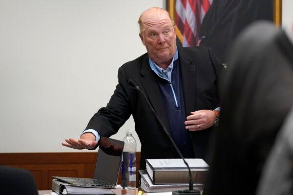  Celebrity chef Mario Batali places items on a table in a court room at Boston Municipal Court on the first day of his pandemic-delayed trial in Boston on May 9, 2022. (Steven Senne/AP Photo)