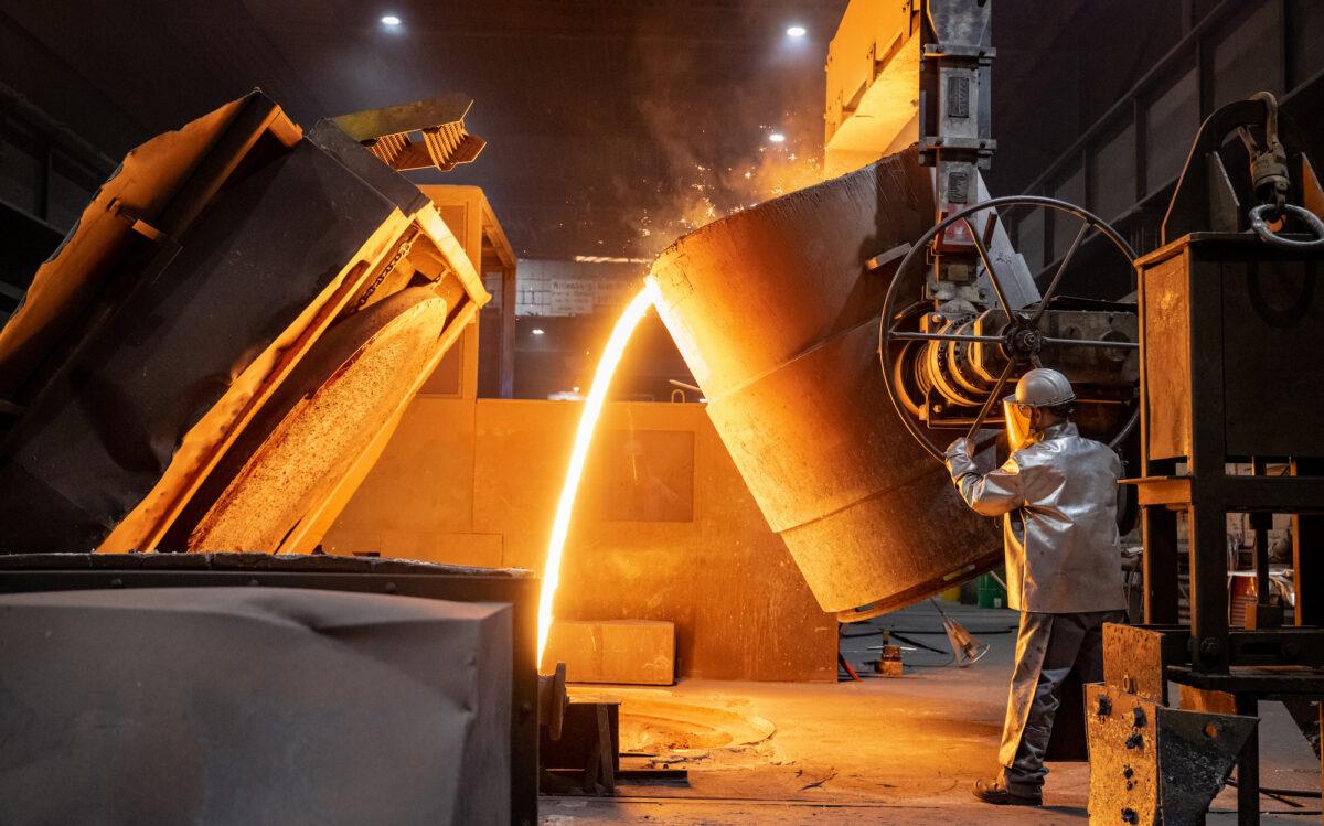 A German worker pours molten iron into a mould at the Siempelkamp Giesserei foundry in Krefeld, Germany, on April 21, 2022. (Sascha Schuermann/Getty Images)