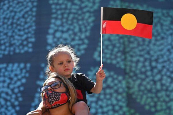 A young girl holds up an Australian Aboriginal flag on Australia Day in Sydney on Jan. 26, 2022. (Steven Saphore/AFP via Getty Images)