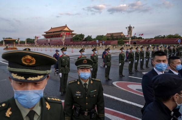 Police officers and security block the way as they perform crowd control after an official flag raising ceremony to mark National Day next to Tiananmen Square and the Forbidden City in Beijing, China, on Oct. 1, 2021. (Kevin Frayer/Getty Images)