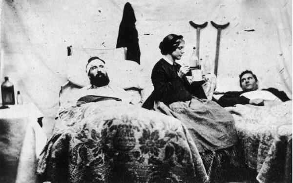 A nurse prepares to spoon-feed soldiers in this photograph taken by Jim Enos inside the Union hospital at Carlisle Barracks, Penn., circa 1861. (Fotosearch/Getty Images).
