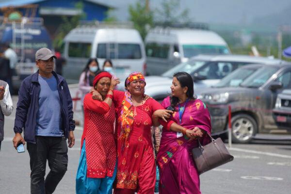 Relatives of passengers of the Tara Air turboprop Twin Otter plane that crashed wail outside the airport in Pokhara, Nepal, on May 30, 2022. (Yunish Gurung/AP Photo)