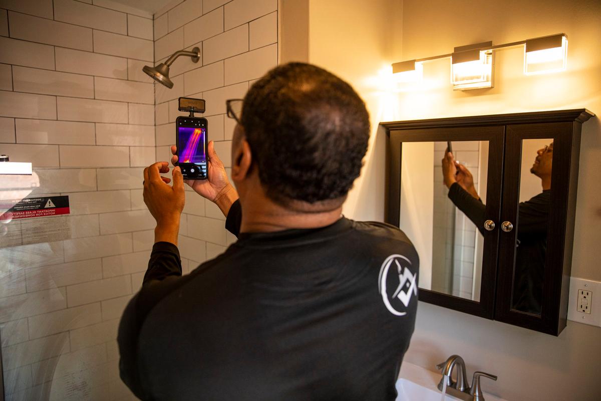 Ben Poles, owner of Rest Assured Inspections, takes a photo and checks the temperature of the water in the shower during a home inspection in Drexel Hill, Pennsylvania. (Tyger Williams/The Philadelphia Inquirer/TNS)