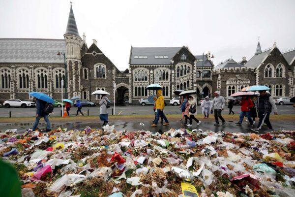 People walk past flowers and tributes displayed in memory of the twin mosque massacre victims outside the Botanical Gardens in Christchurch, New Zealand, on April 5, 2019. (Sanka Vidanagama/AFP via Getty Images)