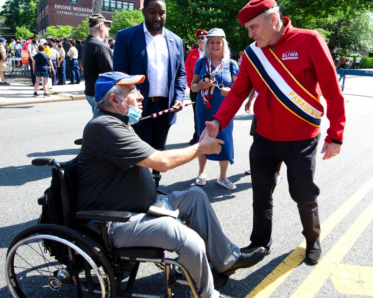 Guardian Angels founder and 2021 Republican candidate Curtis Siiwa for New York City Mayor greets supporter Charles Albert after the 2022 Memorial Day parade in Little Neck-Douglaston, N.Y., on May 30, 2022.<br/>(Dave Paone:The Epoch Times)