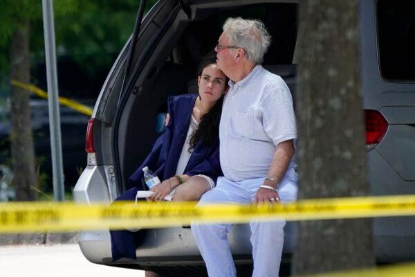  A man comforts a young woman wearing a graduation gown within the crime scene of a shooting at Xavier University in New Orleans, on May 31, 2022. (Gerald Herbert/AP Photo)