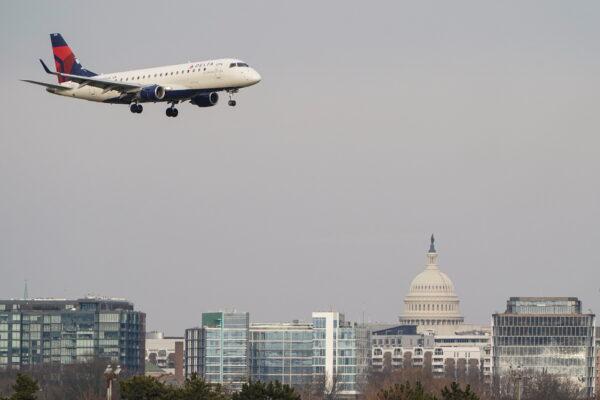 A Delta Air Lines aircraft flies past the U.S. Capitol before landing at Reagan National Airport in Arlington, Va., on Jan. 24, 2022. (Joshua Roberts/Reuters)