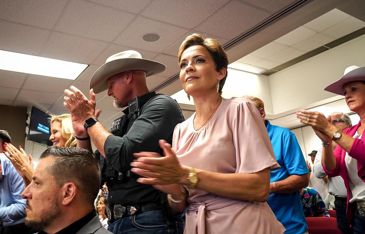 Arizona gubernatorial candidate Kari Lake (C) claps during a presentation of ballot trafficking by True the Vote at Arizona's statehouse in Phoenix on May 31. Next to her is Pinal County Sheriff Mark Lamb. (Allan Stein/The Epoch Times)